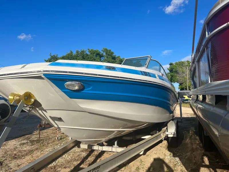 Slide: The Image of 2018 Crownline Eclipse E21 XS boat on a trailer under a clear blue sky. - 10