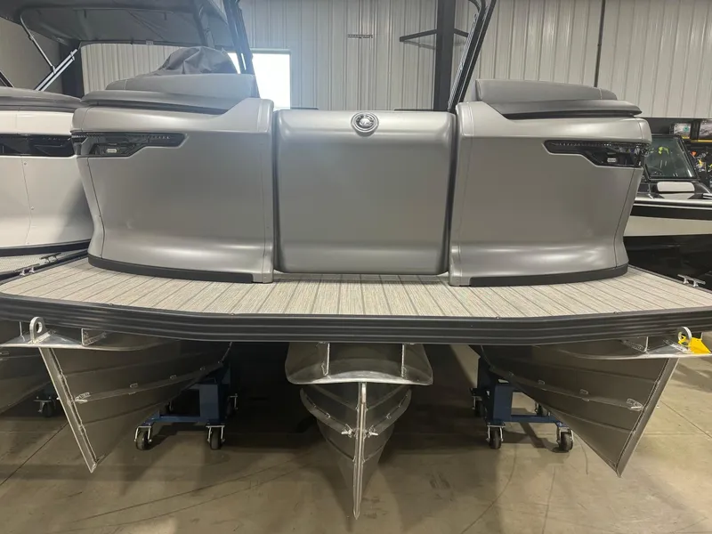 Slide: The Image of 2024 Manitou Explore pontoon boat, rear view in a showroom setting. - 1