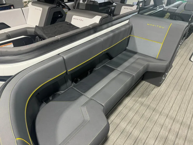 Slide: The Image of 2024 Manitou Explore boat interior with sleek gray seating and yellow accents. - 2
