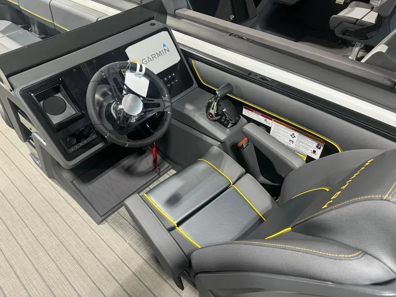 Slide: The Image of 2024 Manitou Explore boat cockpit with Garmin navigation system and sleek black interior. - 4