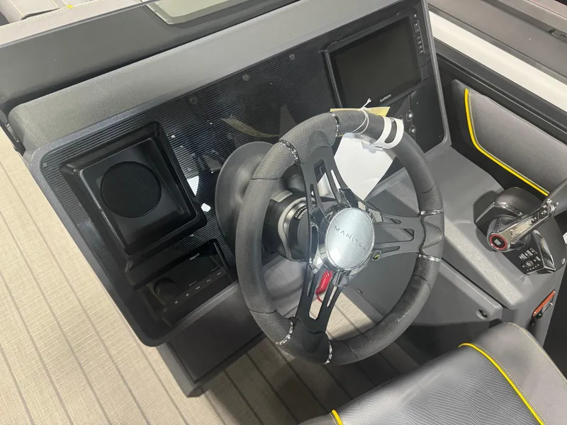 Slide: The Image of 2024 Manitou Explore boat dashboard with steering wheel and control panel. - 6