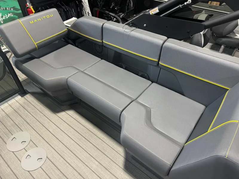 Slide: The Image of 2024 Manitou Explore boat seating with gray upholstery and yellow accents. - 9