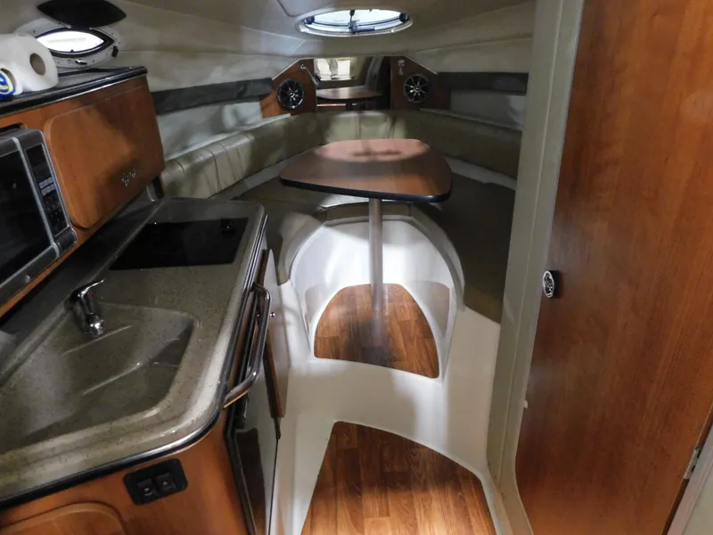 Slide: The Image of 2015 Stingray 250 CS cabin interior with kitchenette, seating, and table. - 10