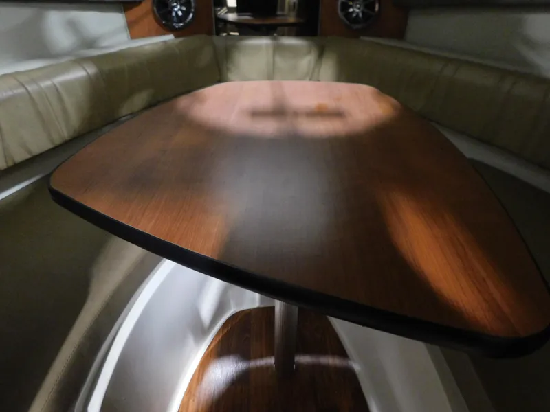 Slide: The Image of Interior of 2015 Stingray 250 CS boat with wooden table and cushioned seating. - 11