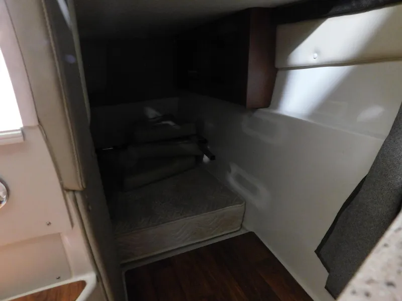Slide: The Image of 2015 Stingray 250 CS cabin interior with bed and wooden flooring. - 13