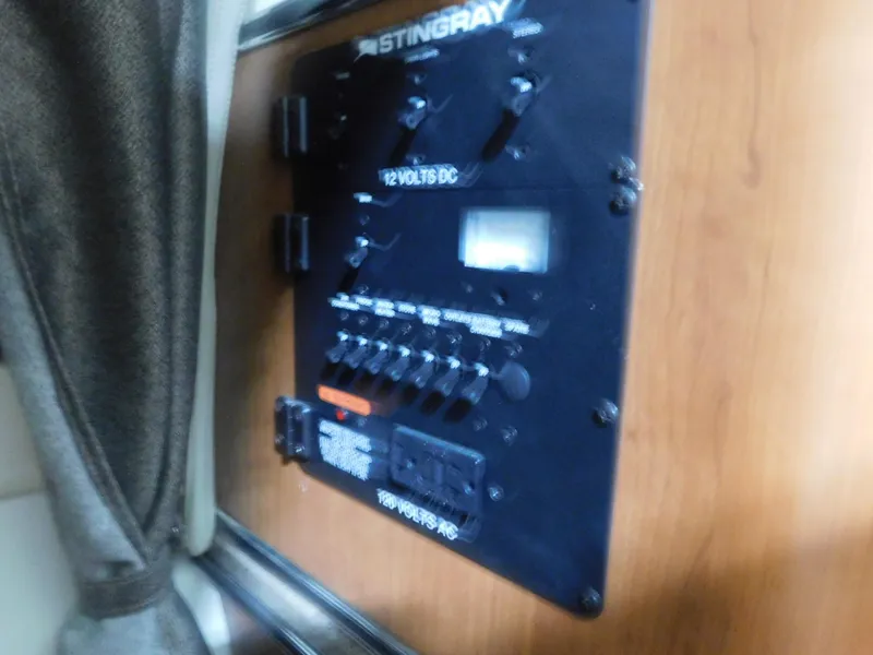 Slide: The Image of Control panel of a 2015 Stingray 250 CS boat, featuring switches and voltage indicators. - 14