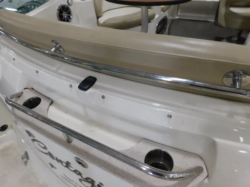 Slide: The Image of 2015 Stingray 250 CS boat interior with beige seating and chrome railings. - 4