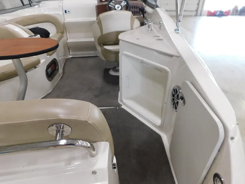 Slide: The Image of 2015 Stingray 250 CS boat interior with seating, table, and storage compartment. - 5