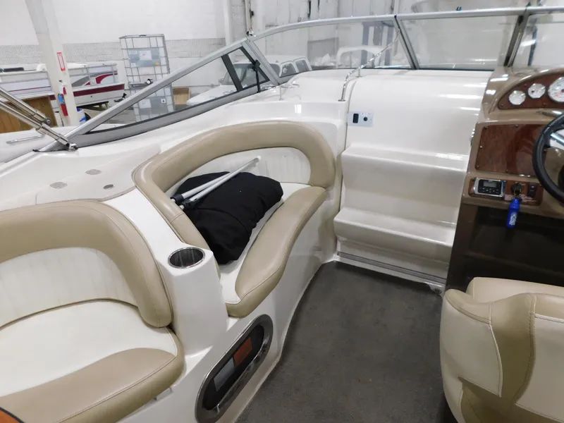 Slide: The Image of 2015 Stingray 250 CS boat interior with beige seating and dashboard. - 7