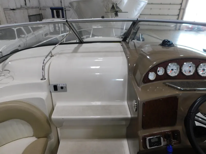 Slide: The Image of 2015 Stingray 250 CS boat interior with dashboard and seating in a garage setting. - 9