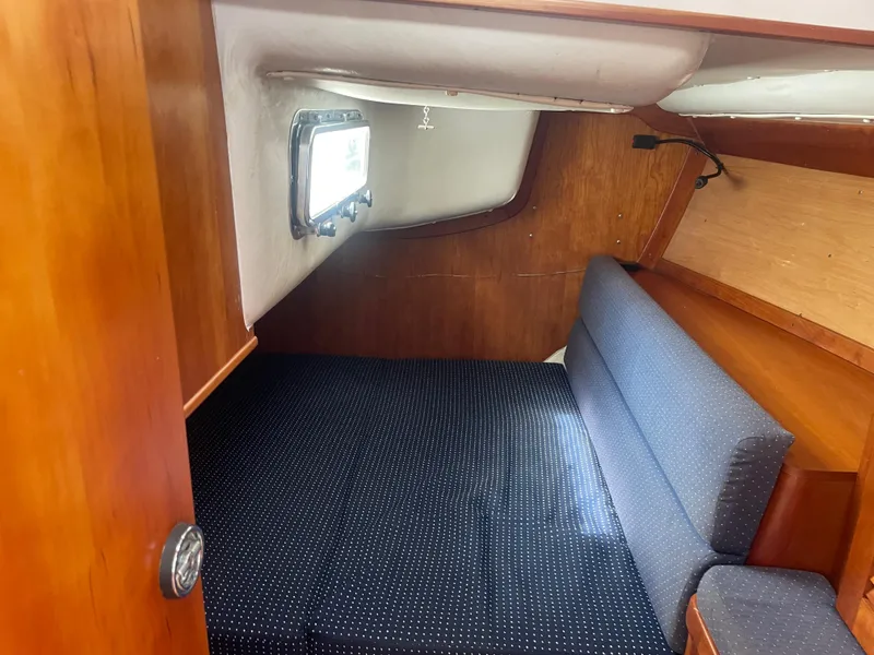 Slide: The Image of 1993 Freedom 35 sailboat cabin with wooden interior and cushioned seating. - 11