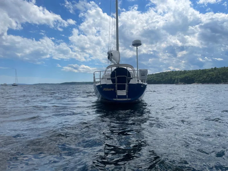 Slide: The Image of Sailboat Freedom 35, 1993 model, on open water under a partly cloudy sky. - 13