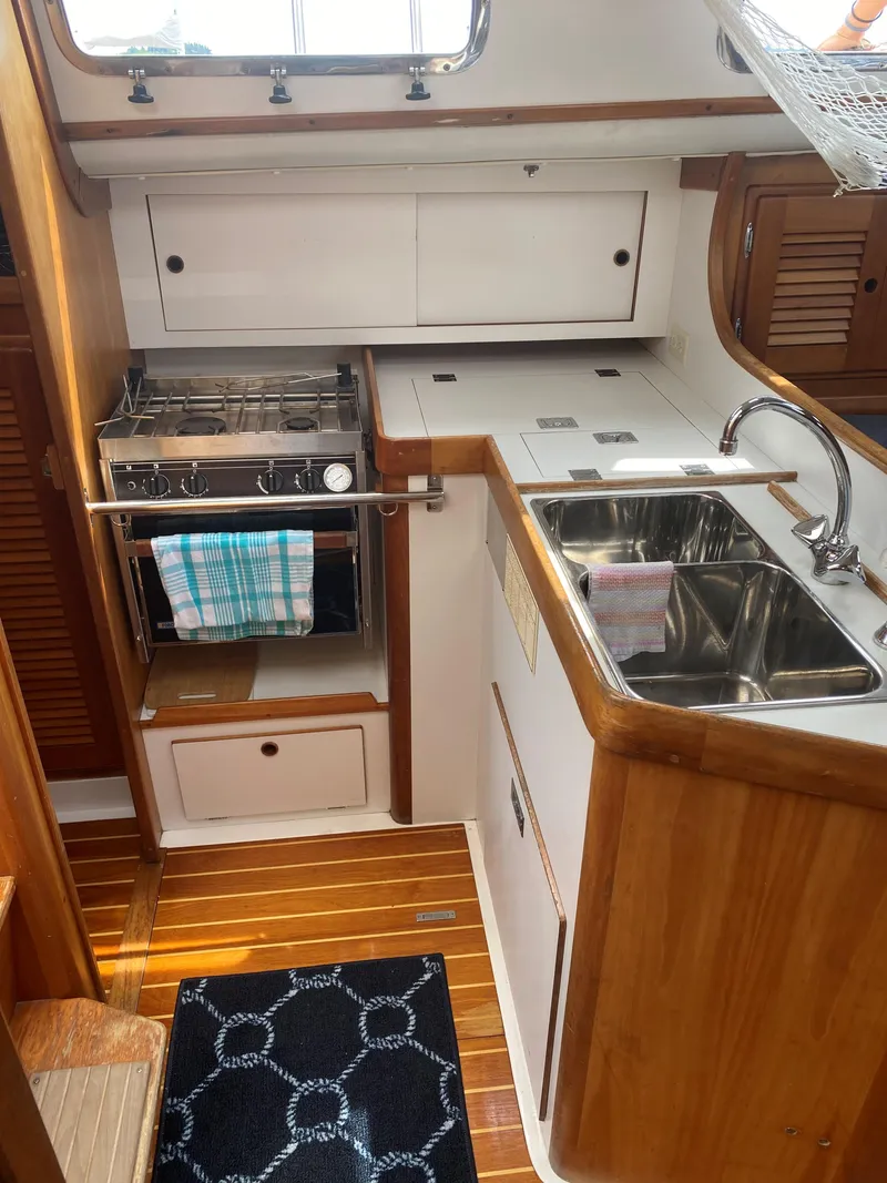 Slide: The Image of Compact kitchen in 1993 Freedom 35 yacht with stove, sink, and wooden cabinetry. - 15