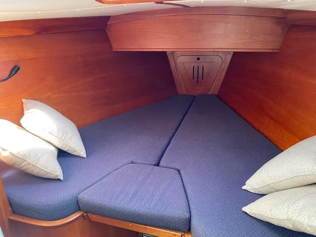 Slide: The Image of Cozy cabin interior of 1993 Freedom 35 sailboat with blue cushions and wooden finish. - 2