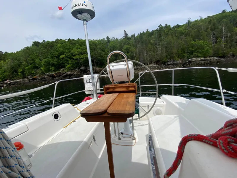 Slide: The Image of Sailboat cockpit view, Freedom 35, 1993 model, with lush forested shoreline in background. - 23