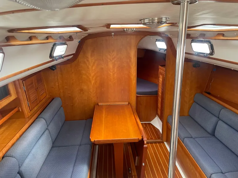 Slide: The Image of 1993 Freedom 35 sailboat interior with wooden finish and blue seating. - 3
