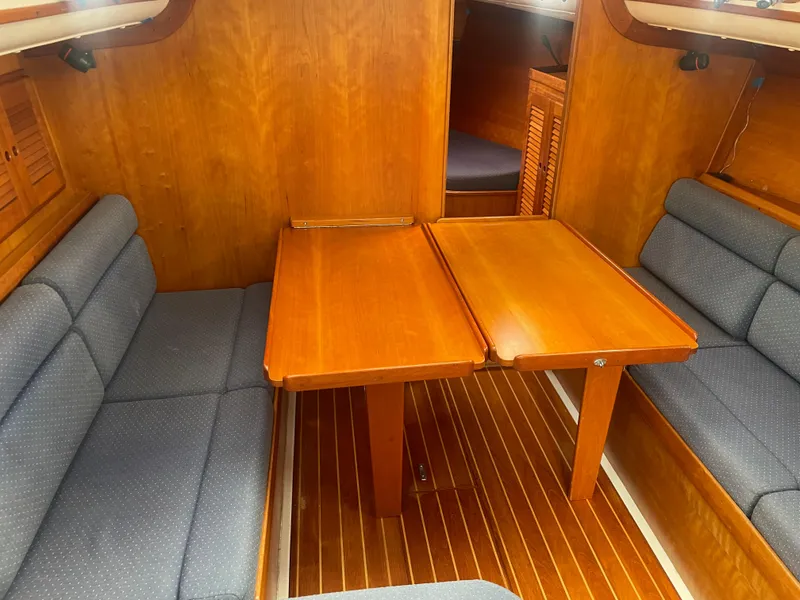 Slide: The Image of Interior of 1993 Freedom 35 sailboat with wooden table and cushioned seating. - 5