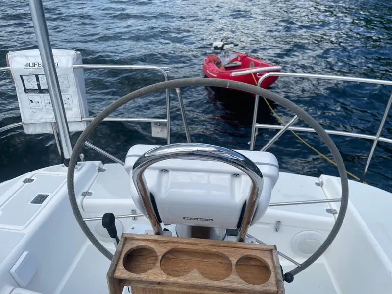 Slide: The Image of Steering wheel of 1993 Freedom 35 sailboat with red dinghy in the water. - 7