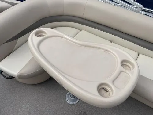 Slide: The Image of 2016 Sun Tracker Fishin' Barge 20 DLX interior with beige seating and table. - 12