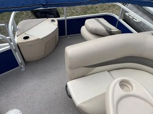 Slide: The Image of 2016 Sun Tracker Fishin' Barge 20 DLX interior with beige seating and storage compartments. - 13