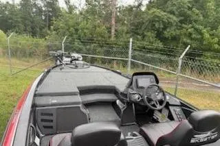 Slide: The Image of 2024 Skeeter ZX200 boat with modern dashboard and seating, parked near a fence. - 5
