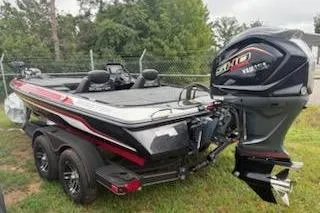 Slide: The Image of 2024 Skeeter ZX200 boat with powerful outboard motor, parked on grass. - 7