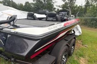 Slide: The Image of 2024 Skeeter ZX200 boat with dual seats, parked on grass near a fence. - 9