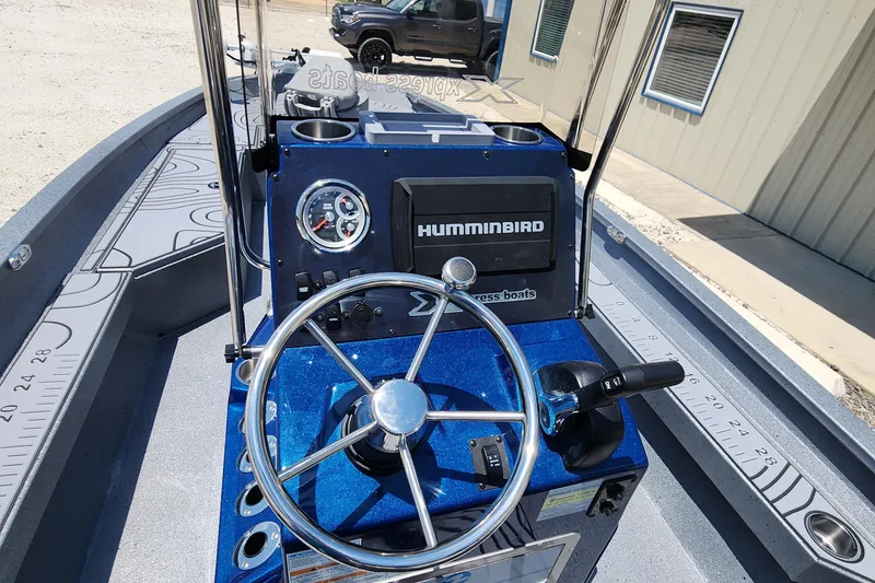 Slide: The Image of 2025 Xpress H20B boat dashboard with steering wheel and Humminbird display. - 16