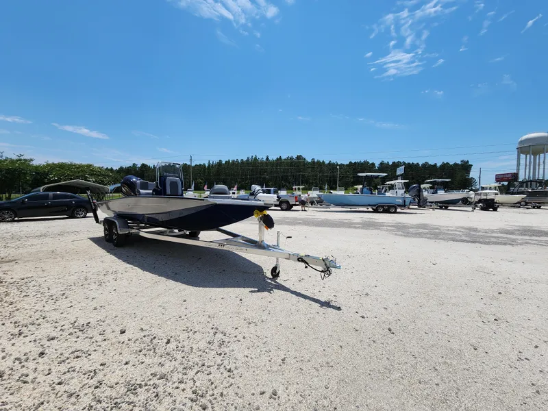 Slide: The Image of 2025 Xpress H20B boat on trailer in sunny parking lot. - 2
