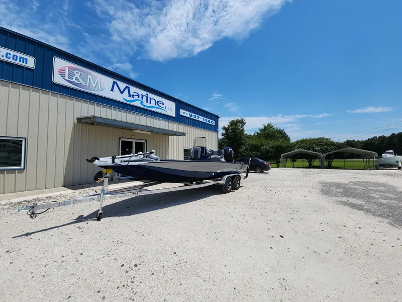 Slide: The Image of 2025 Xpress H20B boat on trailer outside L&M Marine building under clear blue sky. - 3