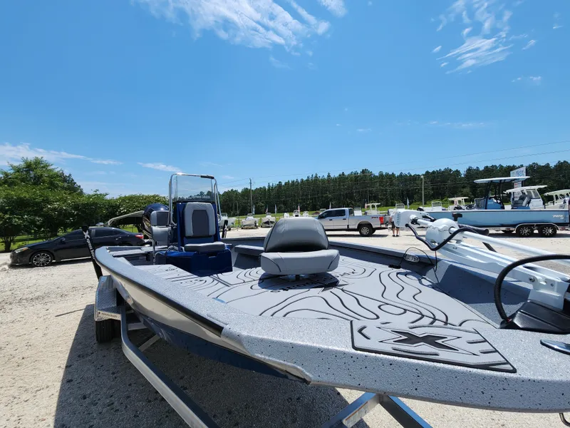 Slide: The Image of 2025 Xpress H20B boat with sleek design, parked outdoors under a clear blue sky. - 6