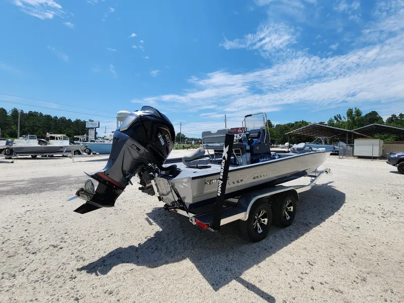 Slide: The Image of 2025 Xpress H20B boat on trailer, parked outdoors under a clear blue sky. - 7