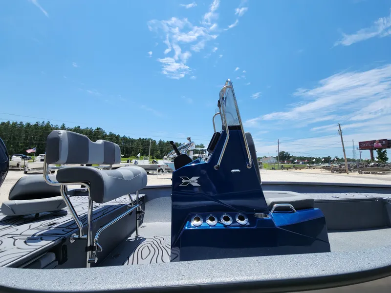 Slide: The Image of 2025 Xpress H20B boat interior with seating and console under clear blue sky. - 9