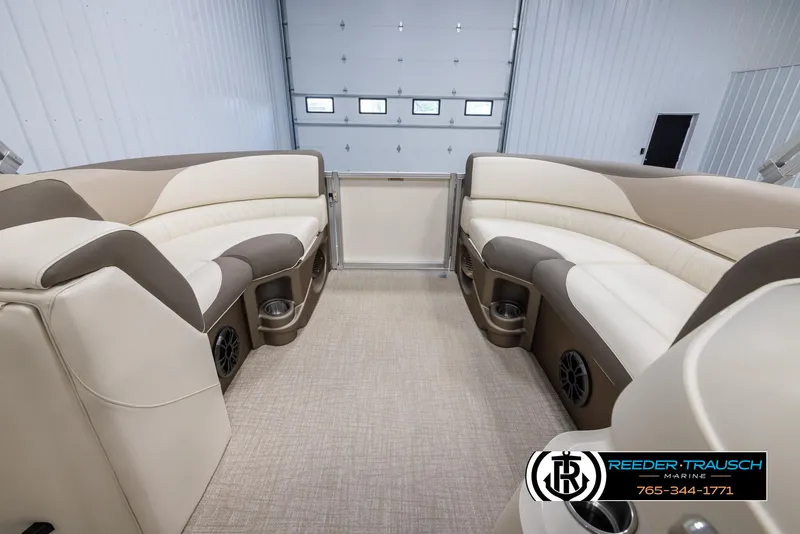 Slide: The Image of 2024 Tahoe LTZ QL boat interior with beige and brown seating, cup holders, and speakers. - 19
