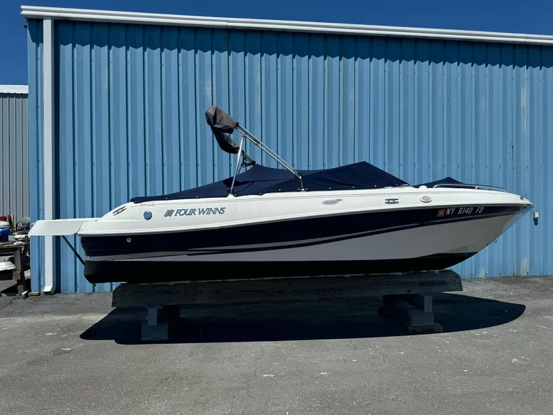 The Image of 2004 Four Winns 200 Horizon boat on display, blue and white, parked outdoors. - 0
