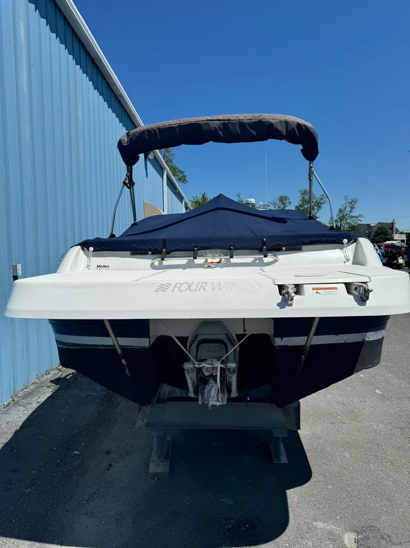 Slide: The Image of 2004 Four Winns 200 Horizon boat, covered and docked, with blue canopy and hull. - 2