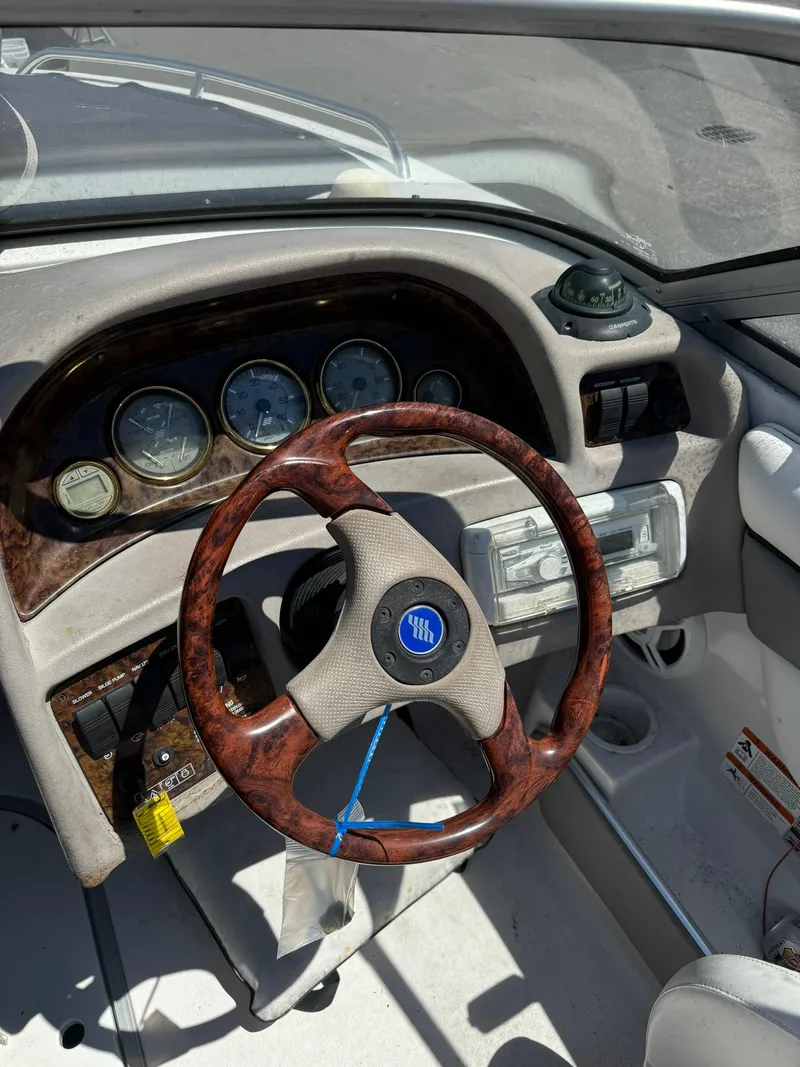 Slide: The Image of 2004 Four Winns 200 Horizon boat dashboard with wood-trimmed steering wheel and gauges. - 7