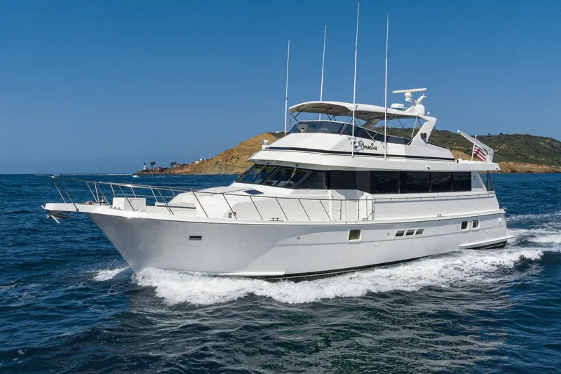 Slide: The Image of 1996 Hatteras 70 Sport Deck Motor Yacht cruising on open water. - 0