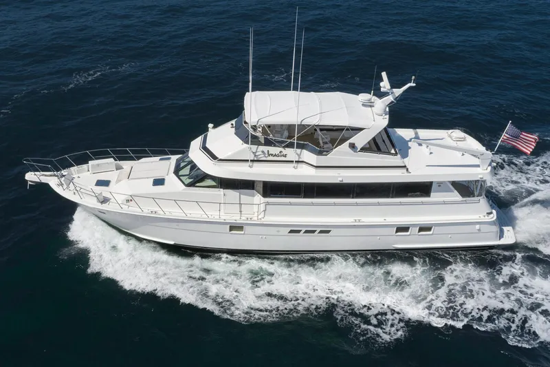 Slide: The Image of 1996 Hatteras 70 Sport Deck Motor Yacht cruising on open water. - 1