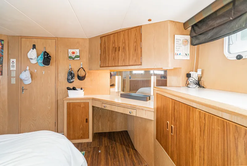 Slide: The Image of 1996 Hatteras 70 Sport Deck Motor Yacht interior with wooden cabinetry and desk. - 26