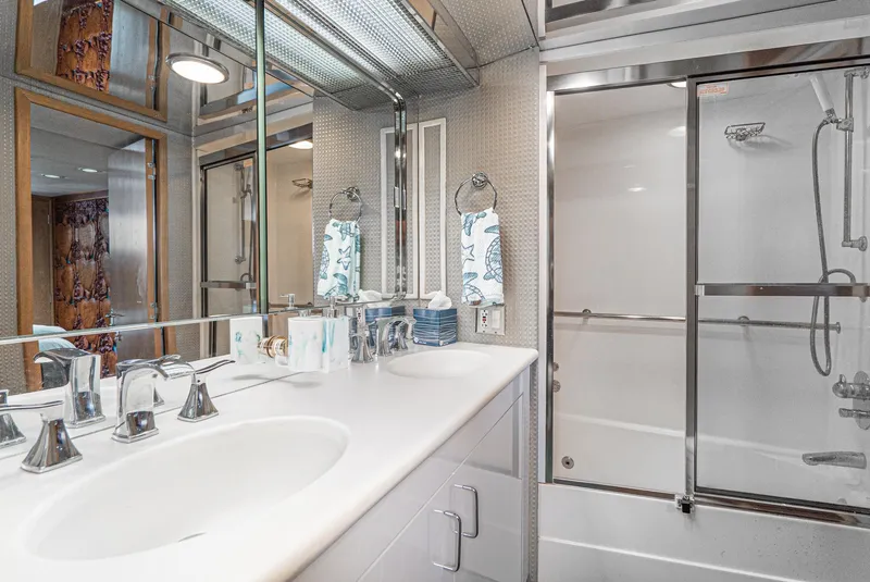 Slide: The Image of Luxurious bathroom in 1996 Hatteras 70 Sport Deck Motor Yacht with double sinks and glass shower. - 28