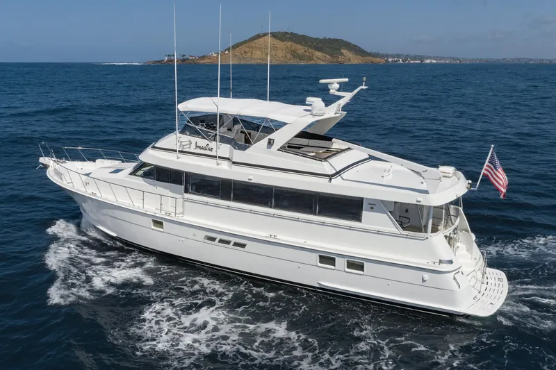Slide: The Image of 1996 Hatteras 70 Sport Deck Motor Yacht cruising on open water. - 45