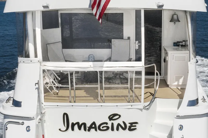 Slide: The Image of 1996 Hatteras 70 Sport Deck Motor Yacht Imagine rear view with American flag. - 46