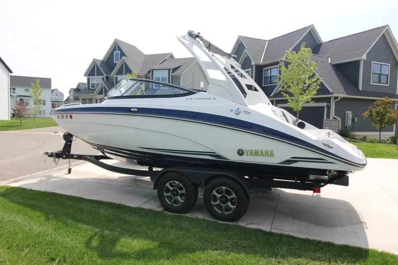 Slide: The Image of 2019 Yamaha Boats 212 Limited S on trailer in residential area. - 3