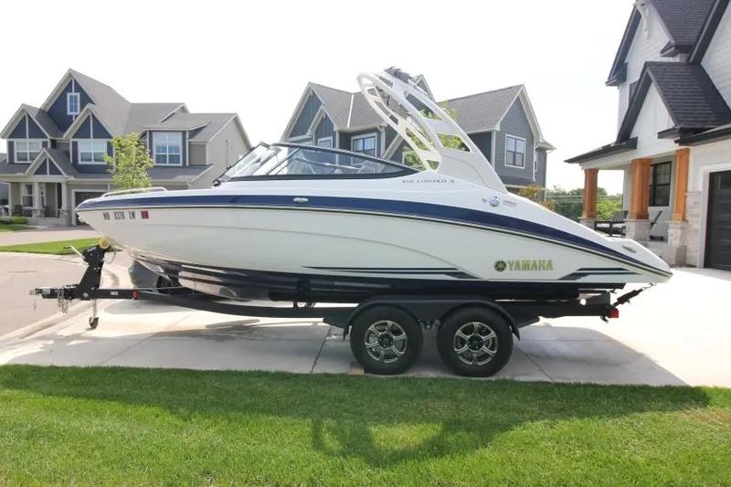 Slide: The Image of 2019 Yamaha Boats 212 Limited S on trailer in residential driveway. - 4