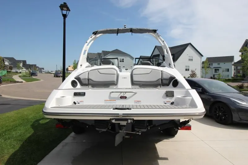 Slide: The Image of 2019 Yamaha Boats 212 Limited S, rear view, parked in a residential driveway. - 5