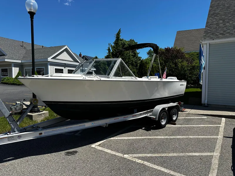 Slide: The Image of 1967 Bertram 20 Moppie boat on a trailer in a parking lot. - 1