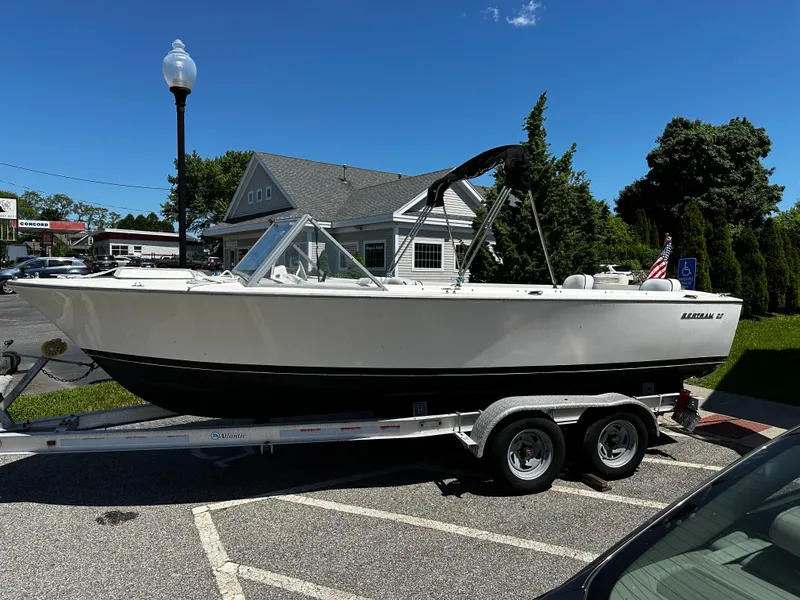 Slide: The Image of 1967 Bertram 20 Moppie boat on a trailer in a parking lot. - 2