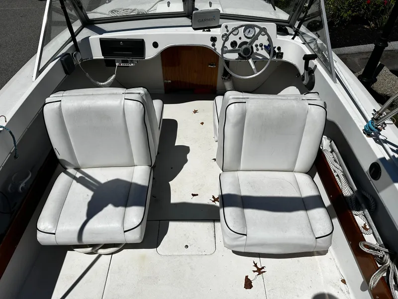 Slide: The Image of 1967 Bertram 20 Moppie boat interior with white seats and steering console. - 4