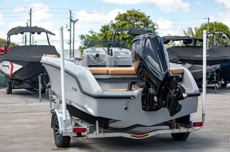 Slide: The Image of 2022 Rand BREEZE boat on trailer, rear view, with outboard motor, parked outdoors. - 12